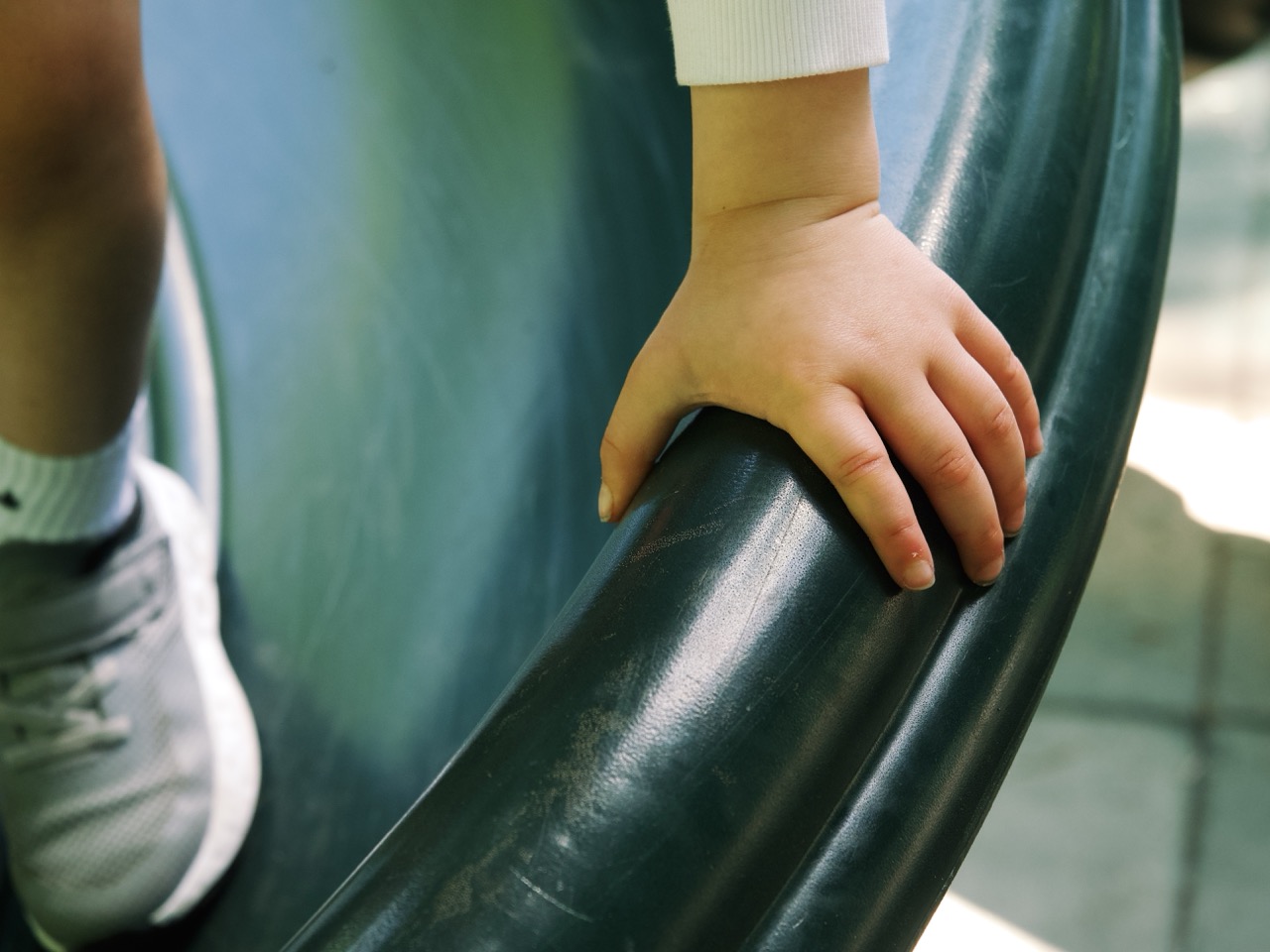 A child's hand gripping playground equipment — candid Omaha family lifestyle photography